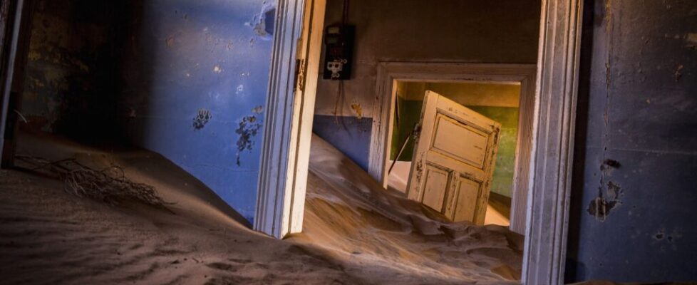 Desert sand filling the rooms of an abandoned house in Kolmanskop, Namibia