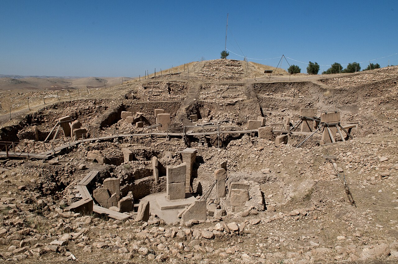 Carved T-shaped limestone pillars inside a circular stone enclosure at Göbekli Tepe, Turkey