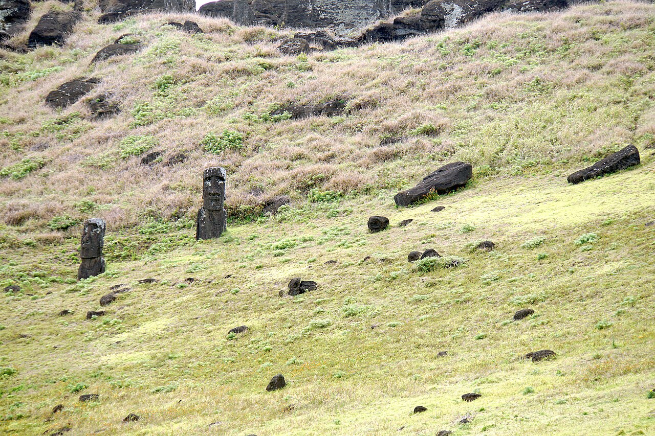 Giant carved stone moai figures standing on the grassy slopes of Easter Island