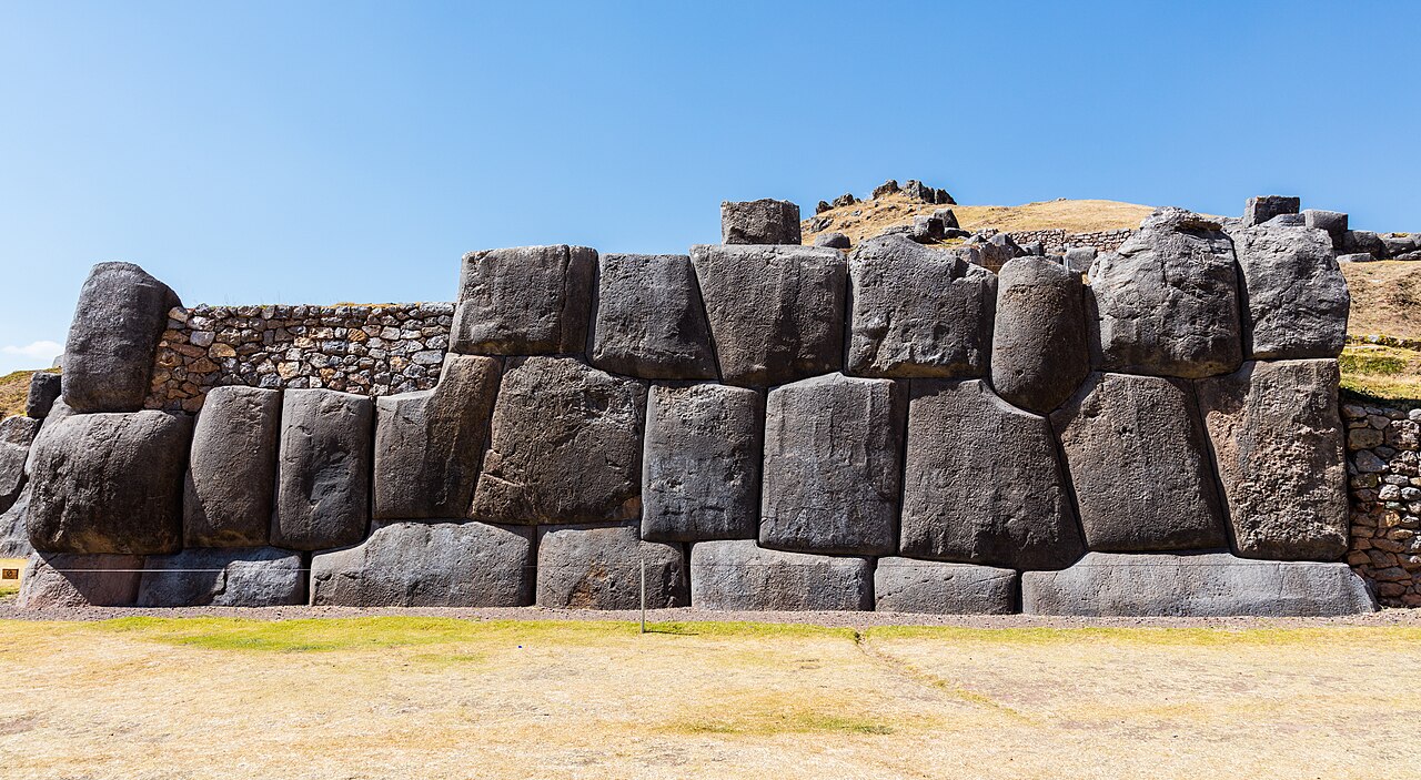 Massive interlocking stone blocks forming the terraced walls of Sacsayhuamán above Cusco, Peru