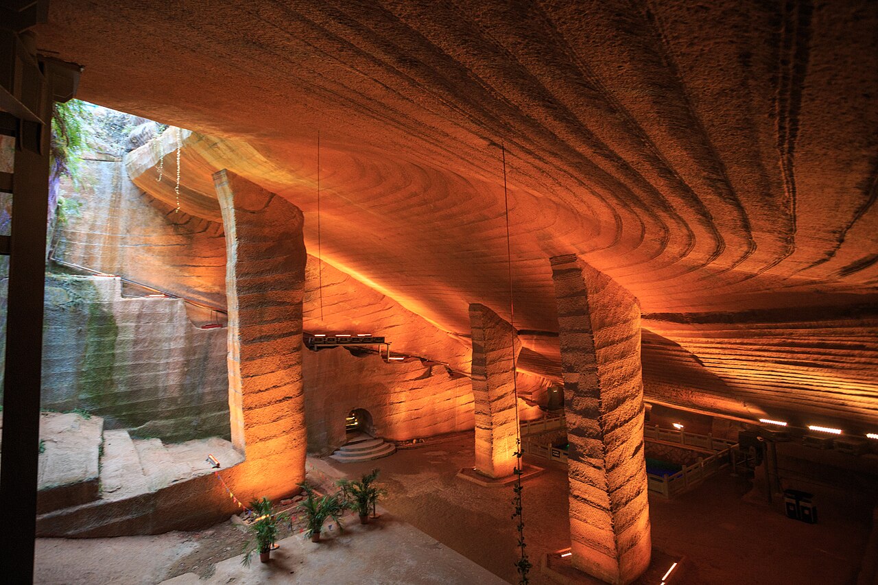 A vast hand-carved underground chamber with stone pillars inside the Longyou Caves