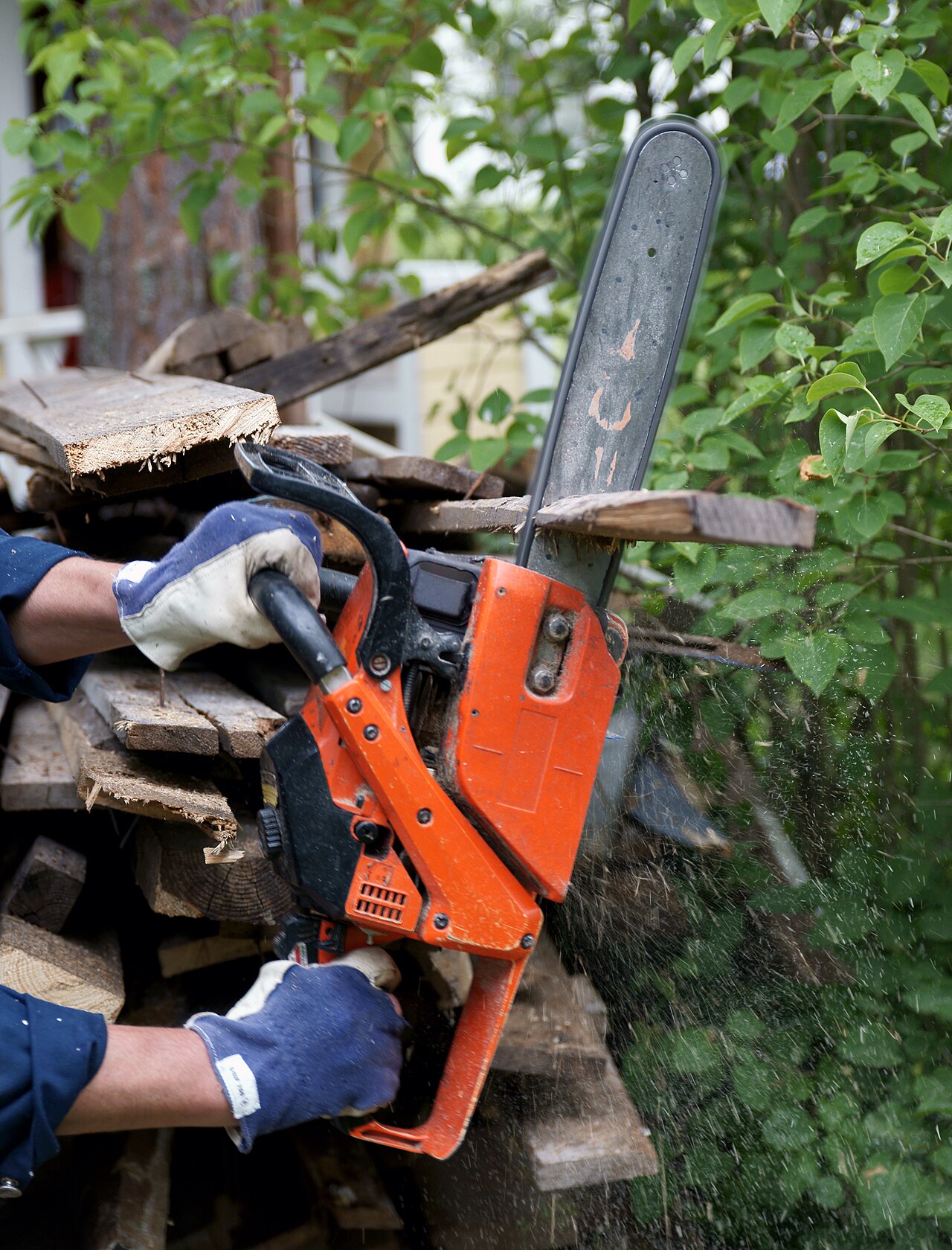 A chainsaw with its toothed cutting chain running around a metal guide bar
