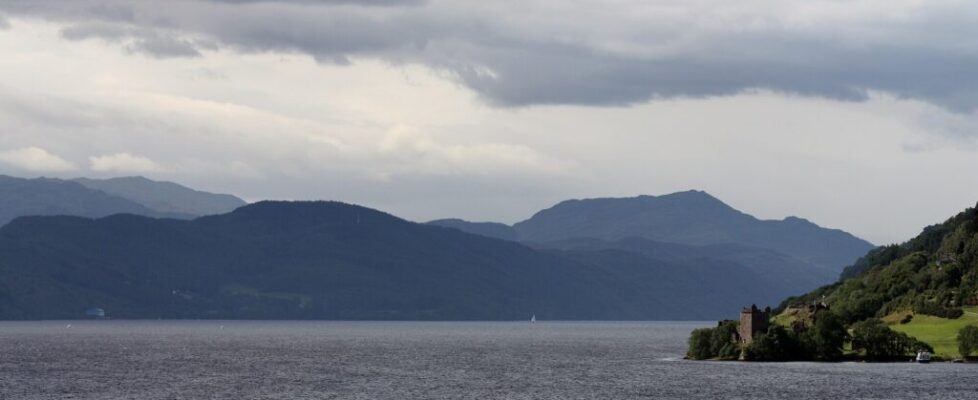 The long, dark waters of Loch Ness stretching between hills in the Scottish Highlands