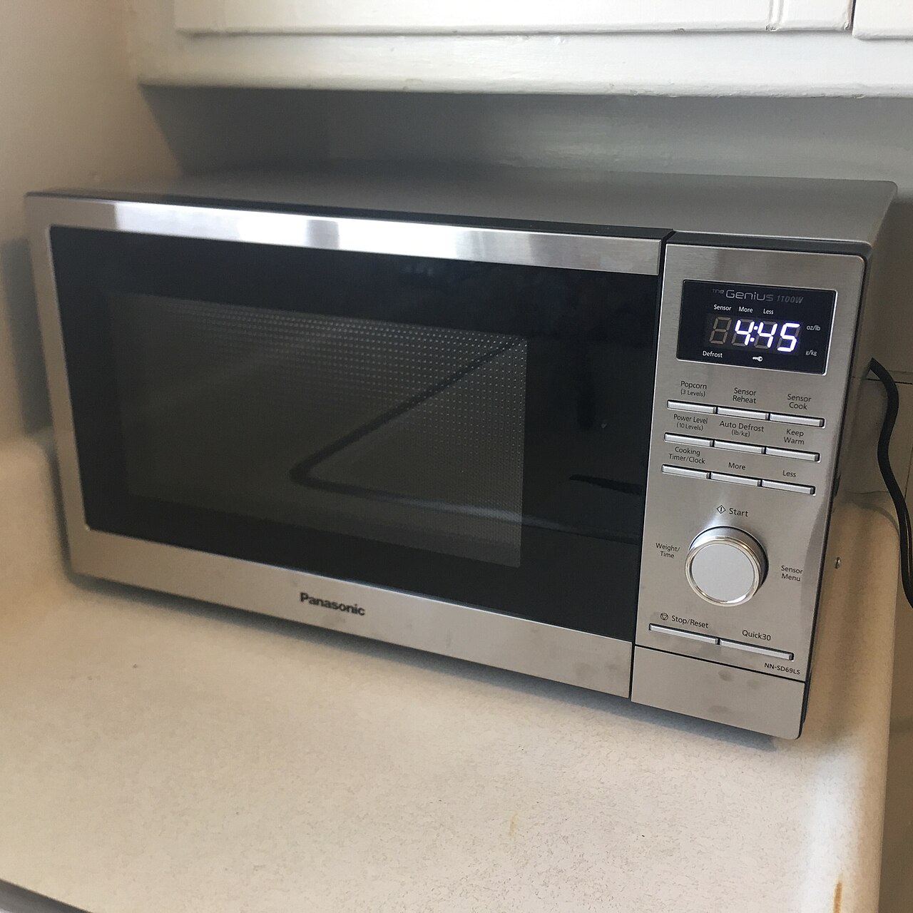 A countertop microwave oven with a glass door and a control panel