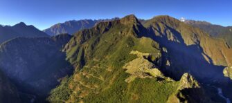 The stone ruins of Machu Picchu on a mountain ridge with Huayna Picchu rising behind