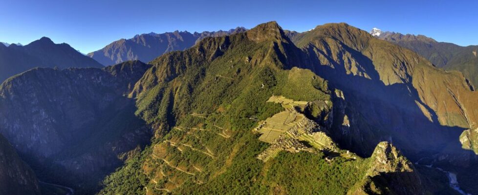 The stone ruins of Machu Picchu on a mountain ridge with Huayna Picchu rising behind