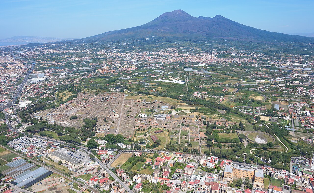 Ruined columns and streets of ancient Pompeii with Mount Vesuvius in the background