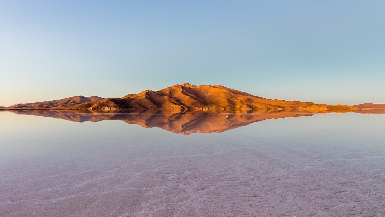 The flat white salt crust of Salar de Uyuni stretching toward distant mountains