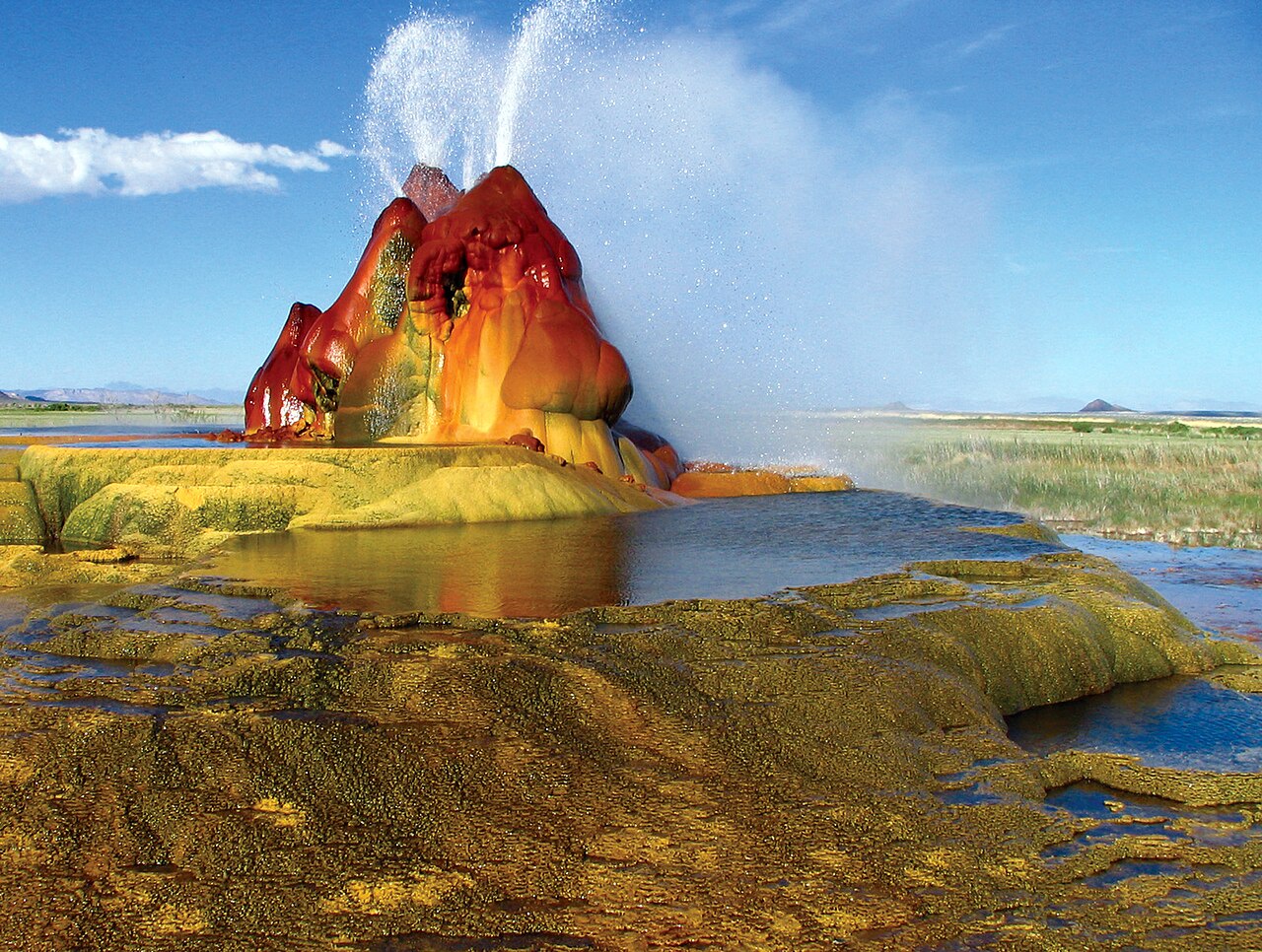 The multicolored mineral cones of Fly Geyser spraying water in the Nevada desert