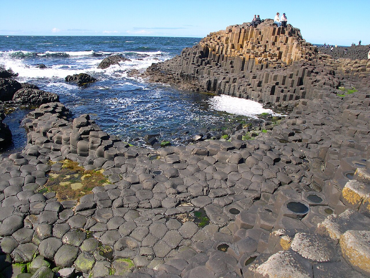 Interlocking hexagonal basalt columns stepping down into the sea at the Giant's Causeway