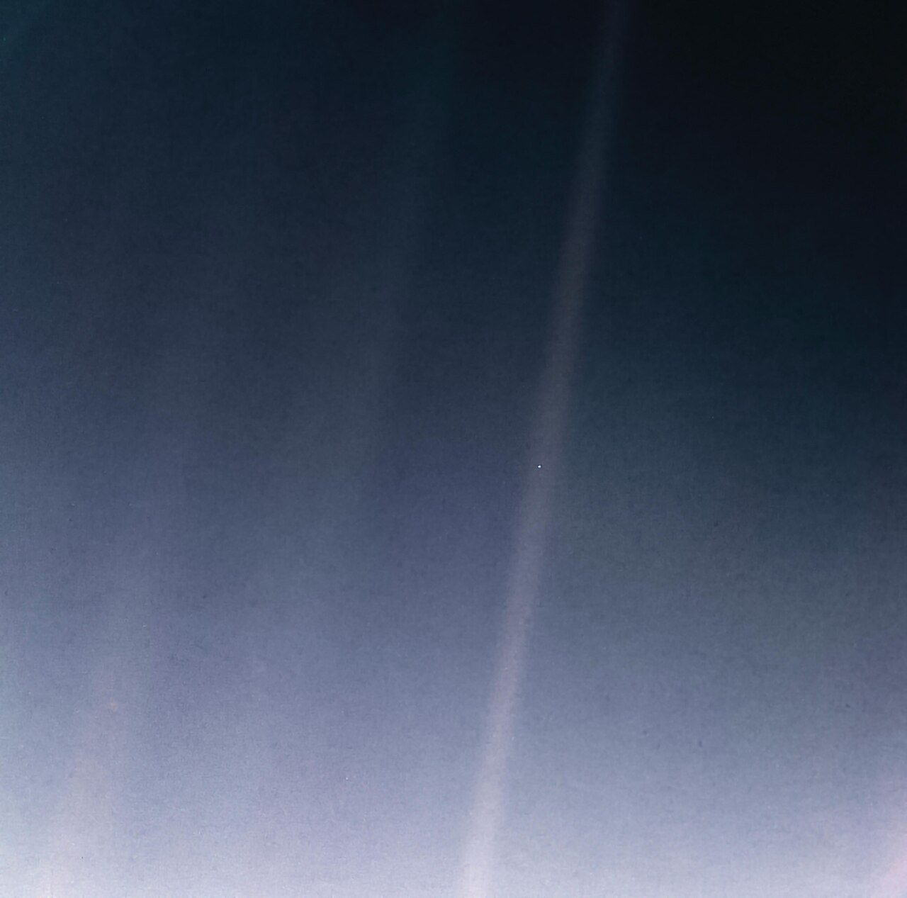The Pale Blue Dot: Earth as a tiny speck within a band of scattered sunlight, photographed by Voyager 1