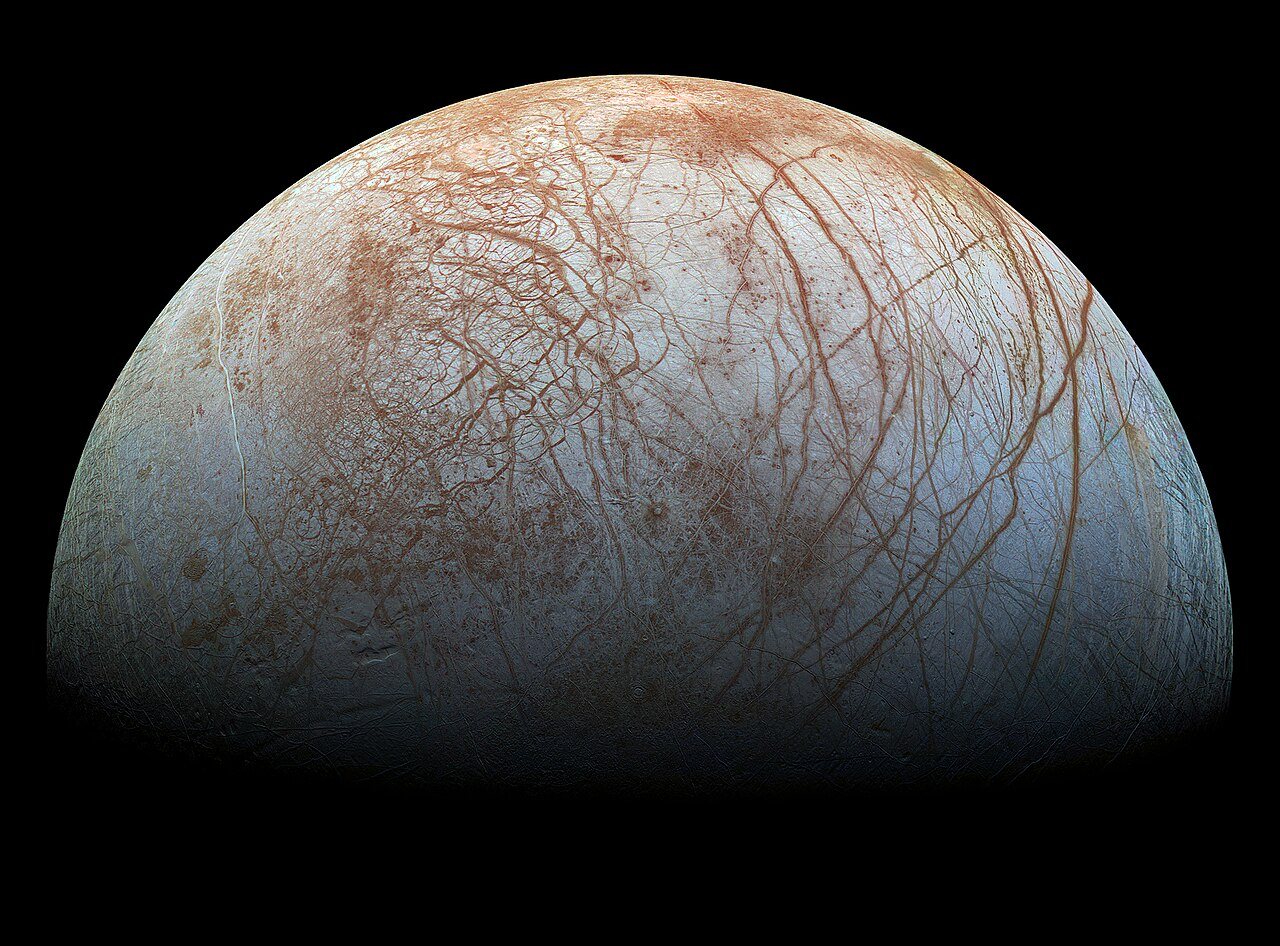 Jupiter’s moon Europa, its icy surface crisscrossed with reddish-brown cracks