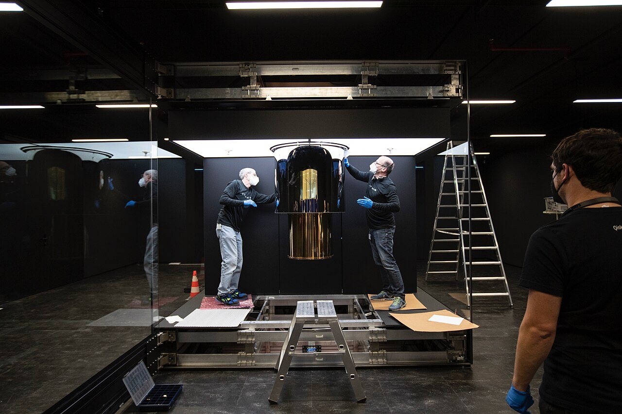Technicians installing an IBM Q System One quantum computer inside a dark lab