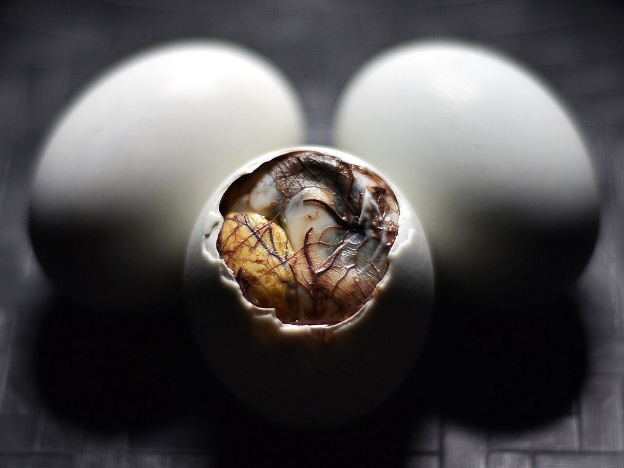 A balut, a fertilized duck egg, partly peeled to show the inside